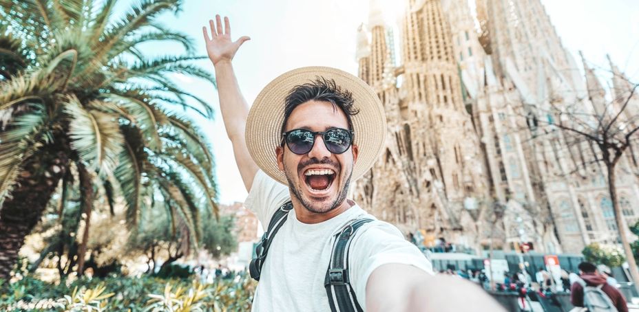 Smiling tourist taking a selfie near Sagrada Familia in Barcelona