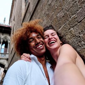 Smiling couple posing for a selfie in front of Gothic Quarter architecture