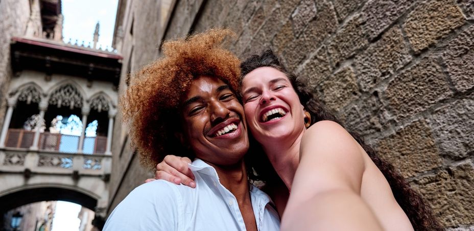 Smiling couple posing for a selfie in front of Gothic Quarter architecture