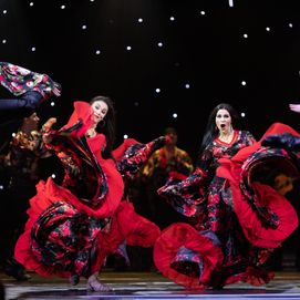 Des femmes en robes à fleurs rouges et noires photographiées alors qu'elles dansent le flamenco.