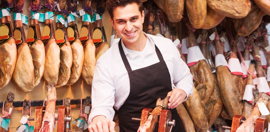 Vendor slicing jamón at La Boqueria market in Barcelona, Spain