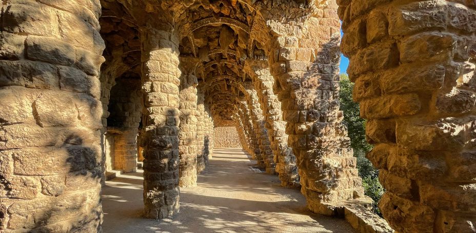 Passageway through ancient stone columns in Park Güell