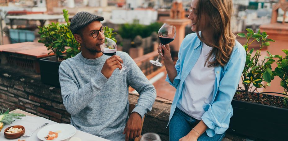 Couple enjoying wine on a rooftop with views of Barcelona cityscape